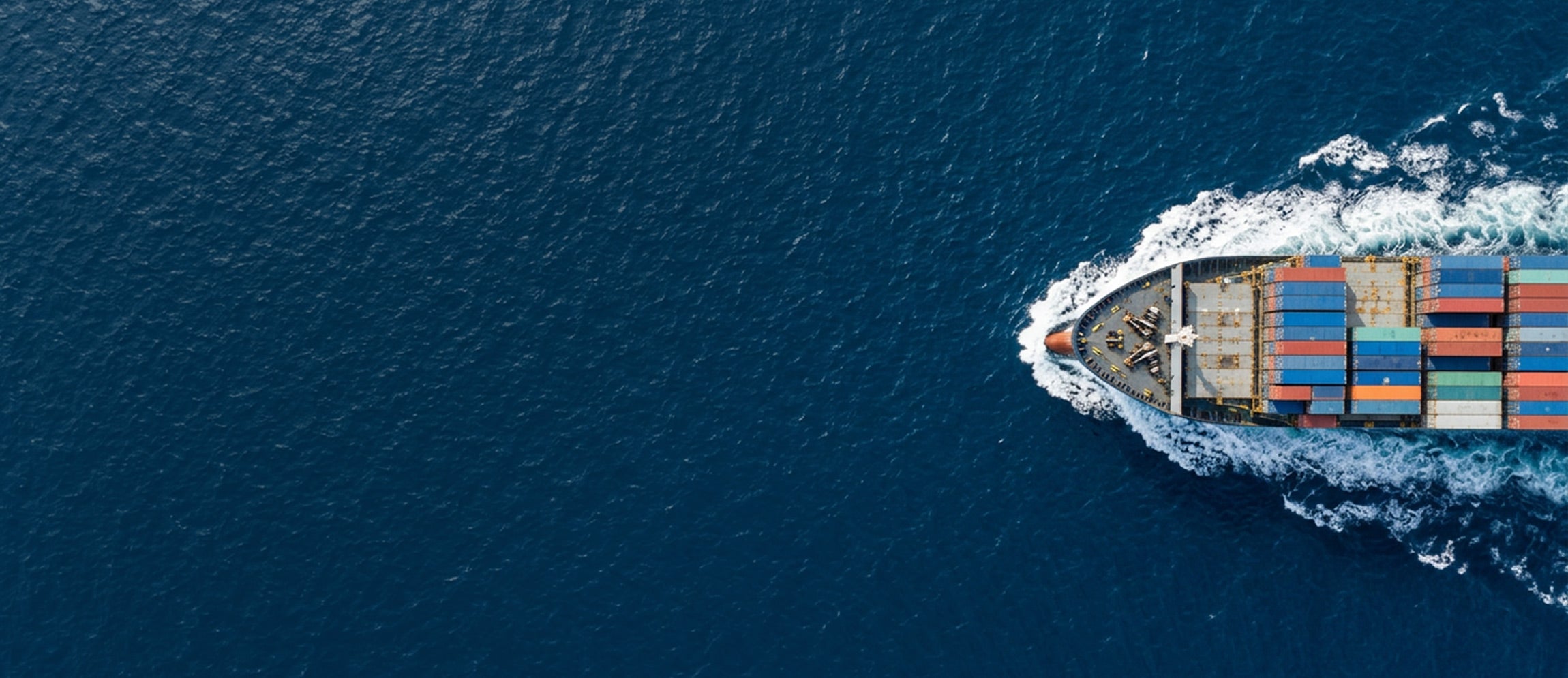 Container ship with colorful cargo containers sailing on a blue ocean.